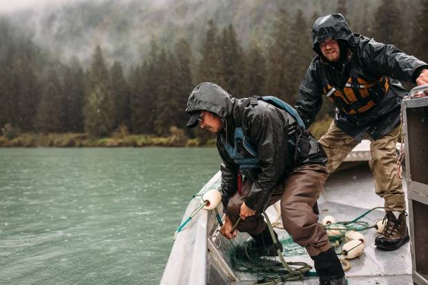 Two salmon fisherman gather their net from the river in River's Inlet, B.C.