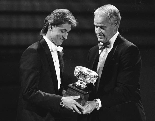 Edmonton Oilers Wayne Gretzky (L) receives the Art Ross Trophy from hall of fame player Gordie Howe during the NHL Awards in Toronto, Ontario, Canada on June 10, 1987.