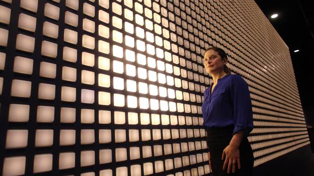 Historian Melanie Morin-Pelletier stands next to an interactive display at the Canadian War Museum. Each light commemorates one of the 3,598 Canadian soldiers killed at the Battle of Vimy Ridge.