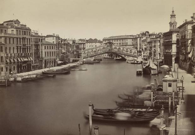 Gondolas along the sides of the Grand Canal in front of the Rialto Bridge, between 1890 and 1899.