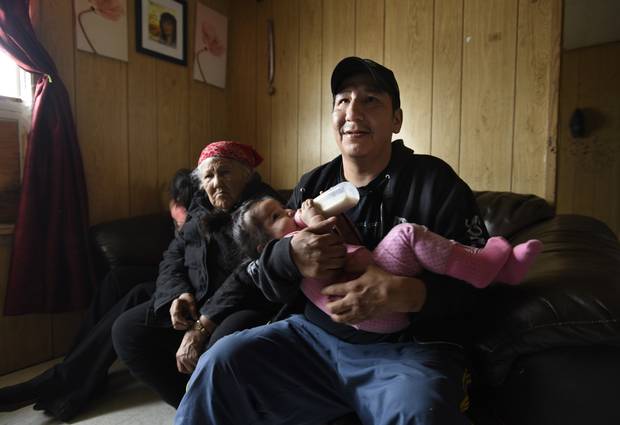 Fraser Meekis hold daughter Makenna while his mother, Adelaide, looks on. On First Nations reserves, life expectancy is five to seven years shorter than that of the general population, studies show.