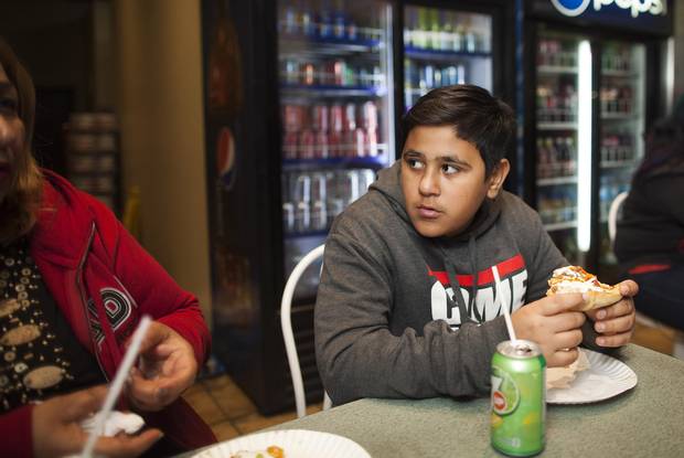 Thirteen-year-old Mike Mohammed chats with his mother, Jamela, over pizza.