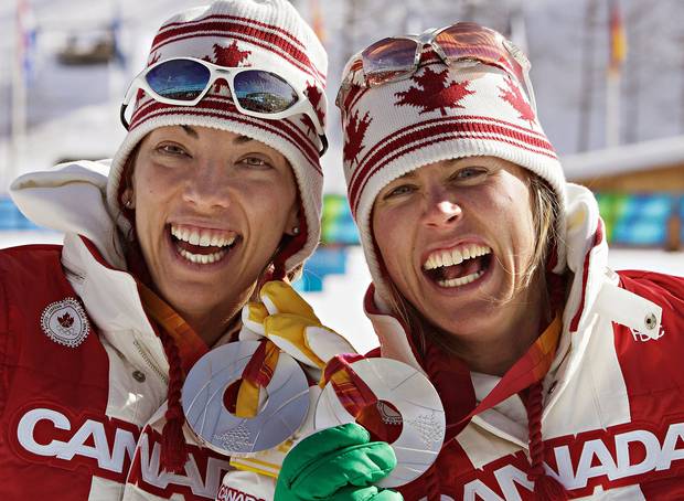 Beckie Scott (left) of Vermillion, Alberta, and Sara Renner of Canmore, Alberta show off their silver medals after winning them in women’s team sprint cross-country skiing competition at the Olympic Games in Pragaleto Plan, Italy on February 14, 2006.