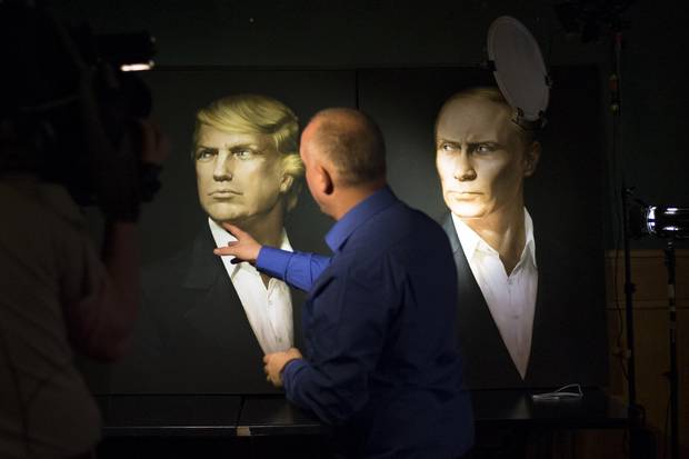 A journalist points at a portrait of Donald Trump and Russian President Vladimir Putin during a live telecast of the U.S. presidential election in the Union Jack pub in Moscow on Nov. 9, 2016.