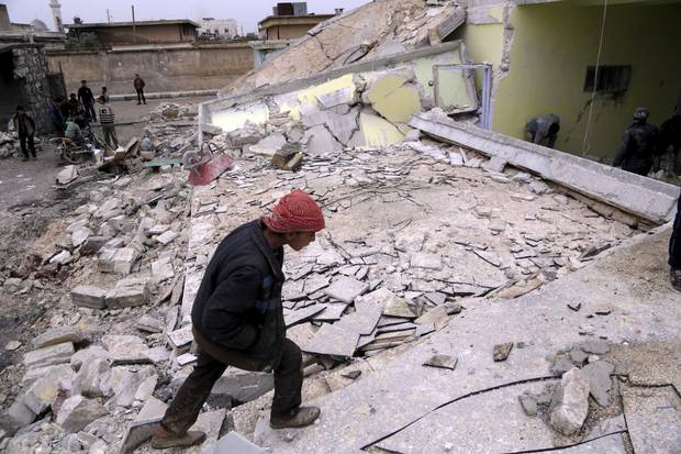 A boy inspects his school, damaged in what activists said was an air strike carried out in January by the Russian air force near Aleppo. Bombs dropped by suspected Russian warplanes killed at least 12 Syrian schoolchildren when they hit a classroom in the rebel-held town, the Syrian Observatory for Human Rights reported.