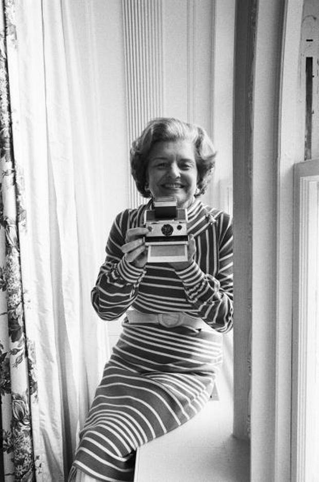 First Lady Betty Ford takes a Polaroid photograph of the official presidential photographer on the patio just outside the White House Oval Office on August 13, 1976 in Washington, D.C.