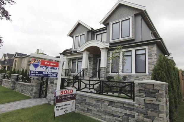 Realtors' signs are hung outside a newly sold property in a Vancouver neighbourhood on Sept. 9, 2014.