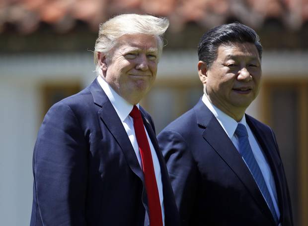 In this April 7, 2017, file photo President Donald Trump and Chinese President Xi Jinping walk together after their meetings at Mar-a-Lago in Palm Beach, Fla.