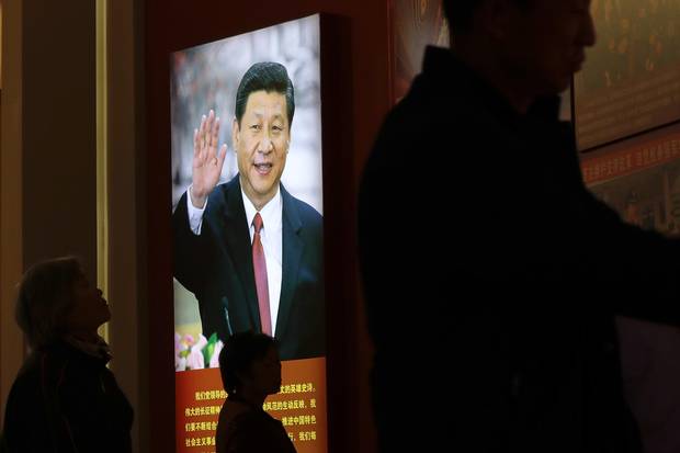 Visitors walk by an image of Mr. Xi at an exhibition on the Long March at the military museum in Beijing on Oct. 24, 2016.