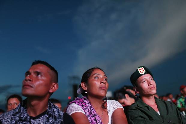 FARC rebels watch the signing broadcast at an encampment in the remote Yari plains.