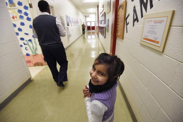 Five year old Mariah Al Rassoul follows Iroquois Junior Public School principal Marcia Pate to her first day in kindergarten class in Toronto. Six Syrian refugee children joined the school on Jan. 4, 2016 after arriving in Canada a month earlier.