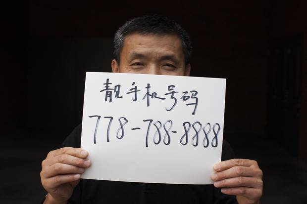 Howard Xu is seen holding up a paper with his lucky phone number.