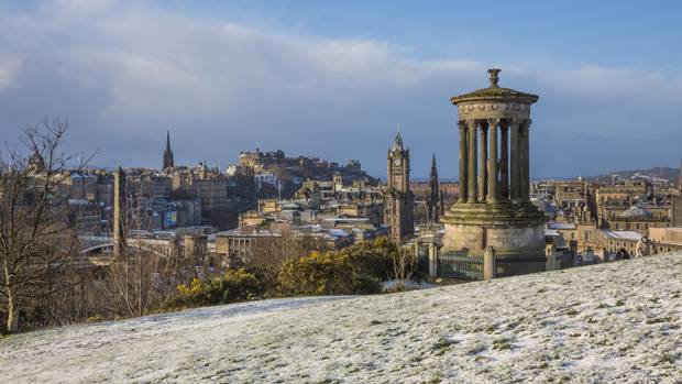 A view over the city of Edinburgh with the Dugald Stewart Monument in the foreground.