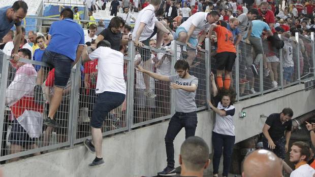 Spectators try to escape from Russian supporters who went on a charge in the stands right after the Euro 2016 Group B soccer match between England and Russia, at the Velodrome stadium in Marseille, France. 