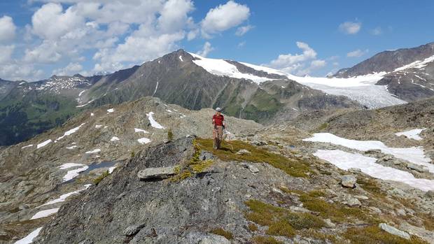 Annelies Ebner hiking in the Selkirk Mountains of British Columbia, the Durrand Glacier and Tumbledown Mountain behind her.