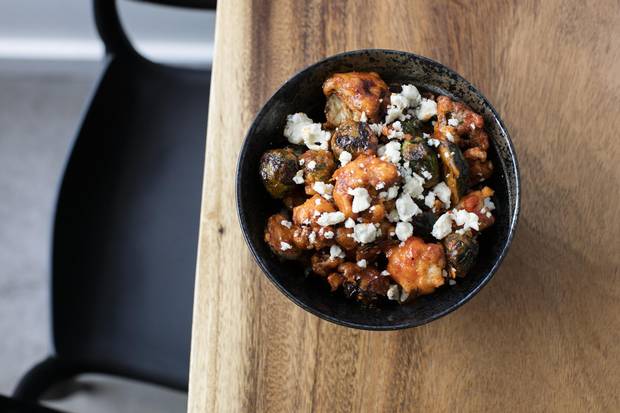Dynamic Duo prepared with rice battered brussels sprout and cauliflower bites, gochujang buffalo sauce and blue cheese crumble.