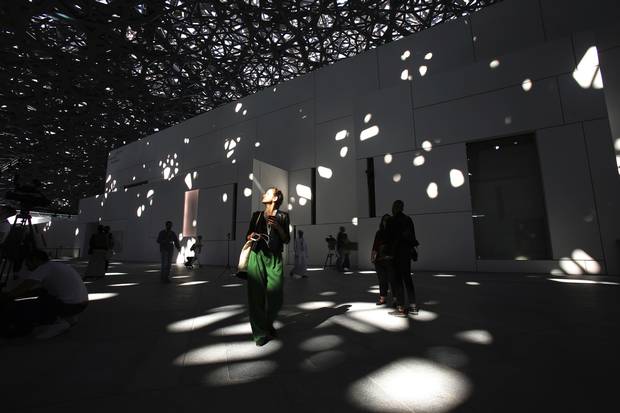 A journalist walks under light coming through a dome roof at the Louvre Abu Dhabi in this Nov. 6 photo.