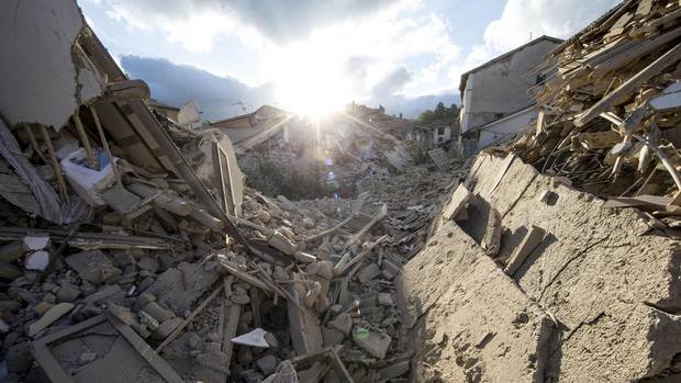 The sun rises over collapsed buildings following an earthquake in Amatrice, central Italy, on Aug. 24, 2016.