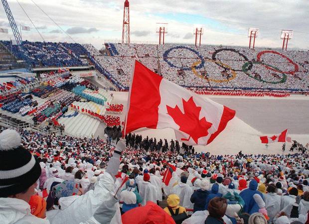 Fans cheer and wave flags as the Canadian delegation parades during the opening ceremony of the 1988 Winter Olympics in Calgary.