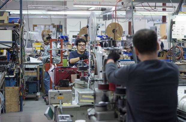 Workers are seen at Toronto's Plitron Manufacturing Inc. on Nov. 2, 2015.