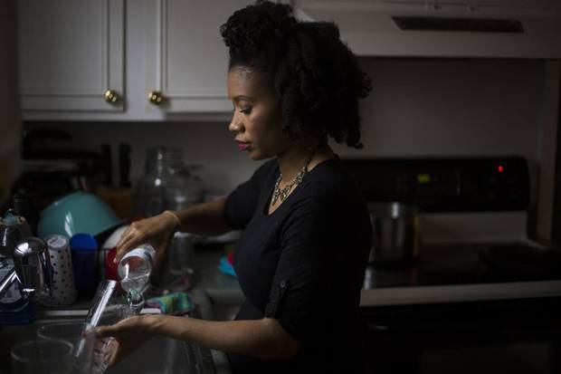 Shanice Ollie washes dishes with boiled bottled water, a process that can take an hour or more, at her home in Flint, Mich., March 5, 2016. Though lead levels in Flint’s tap water have decreased slightly over the last six months, residents are urged to continue using bottled water and filters for drinking, researchers said on April 12.