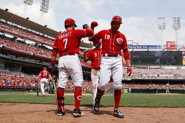 Cincinnati Reds' Joey Votto (19) celebrates with teammate Jose Peraza (9) and Eugenio Suarez (7) after hitting a two-run home run off Colorado Rockies starting pitcher Kyle Freeland in the sixth inning of a baseball game, Sunday, May 21, 2017, in Cincinnati.