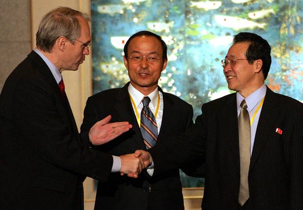 Christopher Hill, left, shakes hands with North Korean chief negotiator Kim Gye-gwan as South Korean deputy foreign minister Song Min-soon, middle, looks on at the close of talks over North Korea's nuclear crisis at the Diaoyutai state guest house in Beijing on Sept. 19, 2005.