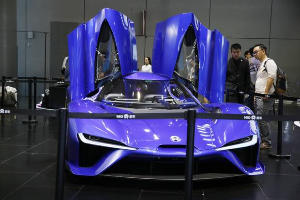 Visitors look at an electric sports car from Chinese startup NIO.