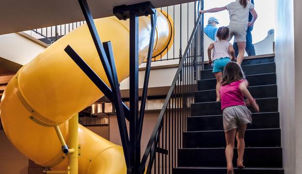 The slide, which cost $8,000, is positioned at a 'hinge point,' between the public rooms and the semi-private rooms.