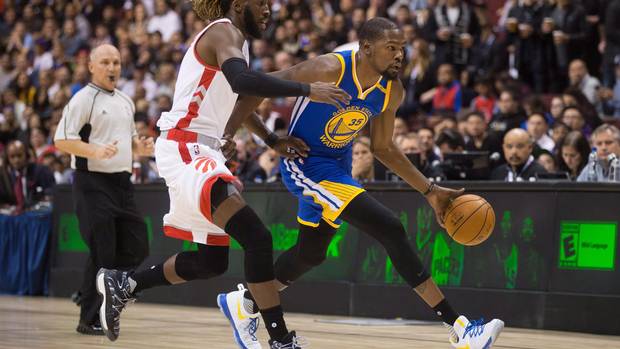 Golden State Warriors' Kevin Durant, right, moves the ball past Toronto Raptors' DeMarre Carroll during first half pre-season NBA basketball action in Vancouver, B.C., on Saturday October 1, 2016.