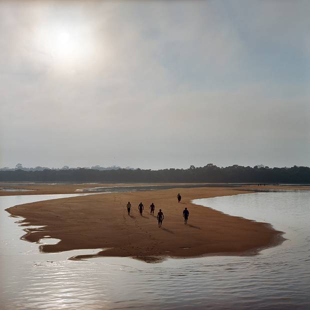 Members of the Munduruku indigenous tribe walk on a sandbar on the Tapajos River as they prepare for a protest against plans to construct a series of hydroelectric dams on their river in in Para State, Brazil. 