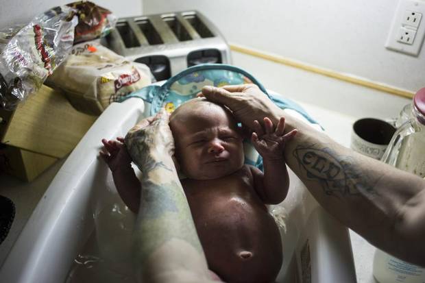 Adam Murphy bathes his newborn son, Declan, using bottled water, at his home in Flint, Mich., April 9, 2016. Reports of rashes, itchiness and hair loss are widespread, despite assurances from government scientists that they have not found any evidence that the city’s lead-tainted water is unsafe for bathing. Many residents say they are bathing less frequently.