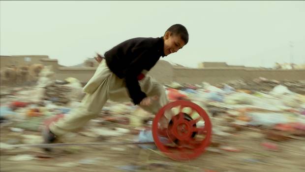 In an earlier work, Francis Alÿs had filmed young boys rolling old bike tires through the streets of Kabul; in his film Reel-Unreel, which is being shown at the AGO, he asked the boys to do the same with spools of film.