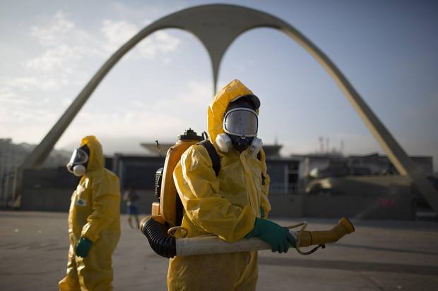 In this Tuesday, Jan. 26, 2016, file photo, health workers spray insecticide to combat the Aedes aegypti mosquito that transmits the Zika virus in Rio de Janeiro, Brazil.