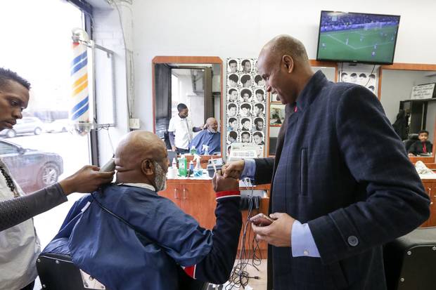 Mr. Hussen chats with Milton Esson while he gets his hair cut.