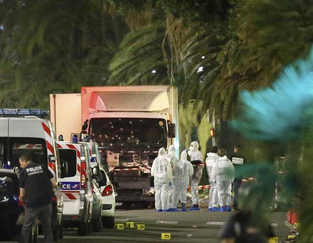 French police forces and forensic officers stand next to a truck July 15, 2016 that ran into a crowd celebrating the Bastille Day national holiday on the Promenade des Anglais killing at least 60 people in Nice, France, July 14.
