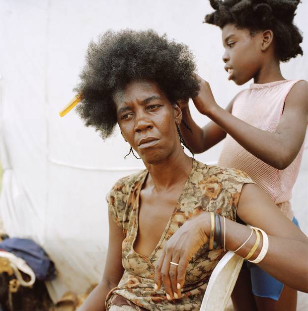 Anse-à-Pitres, Haiti — Emani Escaliste has her hair done by one of her daughters at a displacement camp where she now lives with her children after she was threatened and her house was burnt down in the Dominican Republic. 