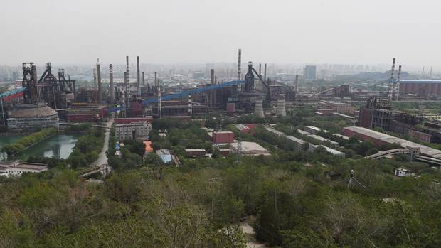This photo taken on May 29, 2015 shows buildings at the Shougang Capital Iron and Steel plant in Beijing. Founded in 1919, Shougang was once the largest steel plant in China, with tens of thousands of workers. But the facility was identified as the Chinese capitals biggest polluter and began a gradual shutdown in 2005 as part of an effort to improve air quality ahead of the 2008 Olympics, finally producing its last steel in early 2011. Local officials have said the 8.6 square km (3.3 square mile) facility will be turned into an arts, tourism and finance hub, but progress has been slow and the decaying site is still reportedly blighted by soil pollution built up during the plants industrial heyday. AFP PHOTO / GREG BAKER (Photo credit should read GREG BAKER/AFP/Getty Images)