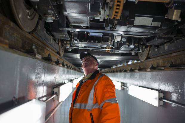 Dan Miller, a consultant from Transdev, takes a look under a QLine car.