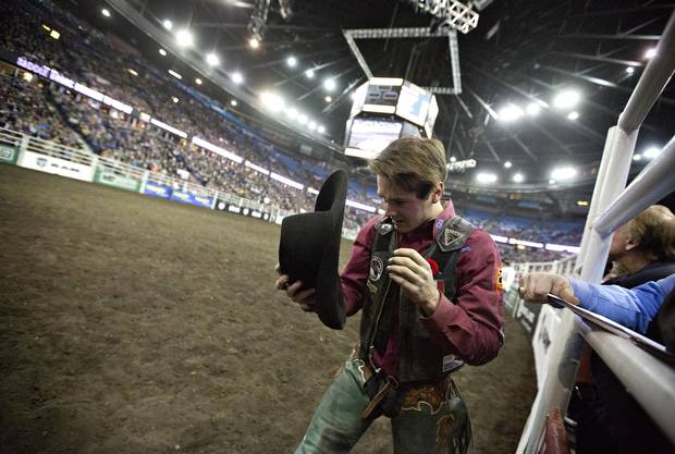 Saddle bronc rider Lane Just picks up his hat after his ride during the Canadian Finals Rodeo in Edmonton Alberta, November 10, 2016.
