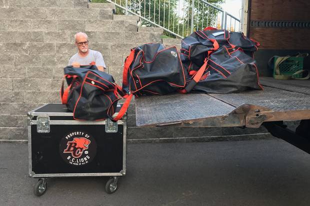 An equipment manager for the B.C. Lions unloads gear from a truck.