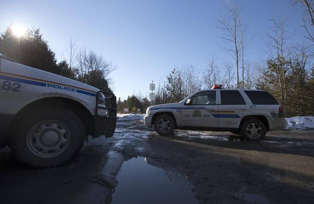 RCMP vehicles are seen down Roxham Road near the Canada-U.S. border in Hemmingford, Que.