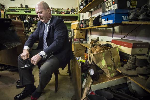 B.C. Finance Minister Mike de Jong tries on his resoled shoes from the Olde Towne Shoe Repair in Victoria on the day before the budget.