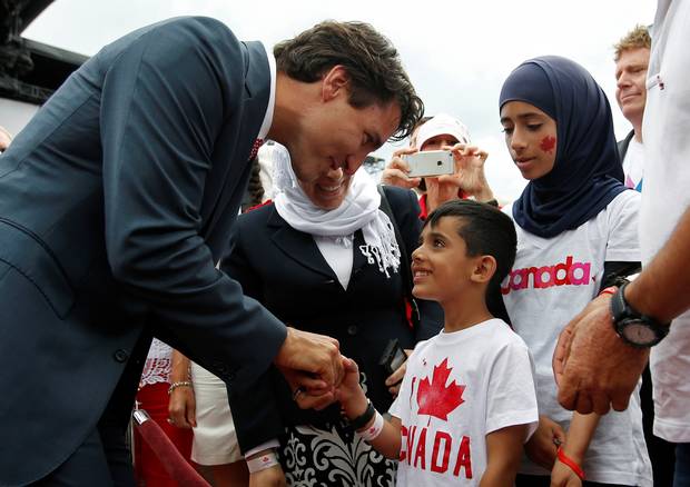 Prime Minister Justin Trudeau shakes hands with a Syrian refugee during Canada Day celebrations on Parliament Hill in 2016.