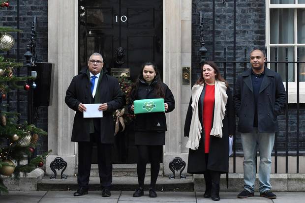 From left to right: Grenfell Tower survivor Nicholas Burton, an unidentifed woman, Sandra Ruiz, whose niece died in the Grenfell Tower fire, and Karim Mussilhy, whose uncle died in the disaster, pose as they deliver a petition to 10 Downing Street on Dec. 12, 2017.