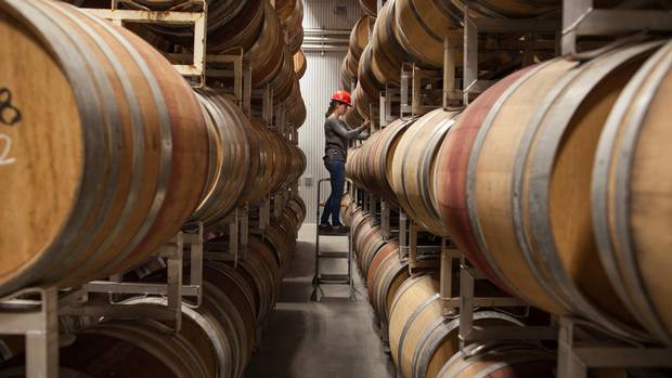 Katlyn Wise, the cellar technician, takes a sample from the barrels for lab analysis at Time Winery in Penticton, B.C.