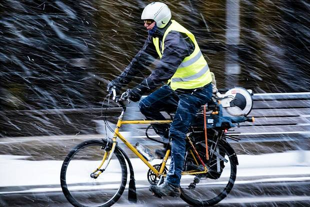 A cyclist kitted out with goggles, lights and a high-visibility vest and helmet braves the first snowfall in Toronto.