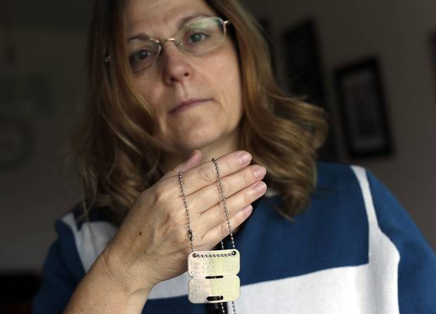 Anita Cenerini holds her son’s dog tags.