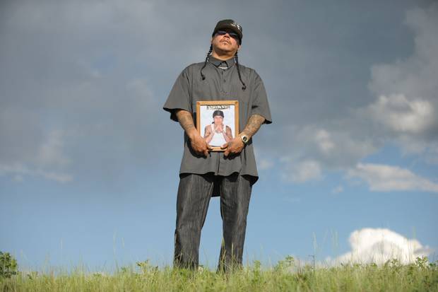 Richard Wolfe holds a photo of his late brother, Daniel Wolfe, on a hilltop near Richard's home in Fort Qu'Appelle, Sask., in 2011.