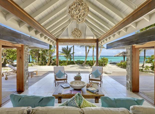 Petit St. Vincent resort’s 22 cottages, left, are spread out on small, intimate sandy beaches and bluffs. The 47-hectare island is lush with tropical vegetation and is surrounded by coral reefs.